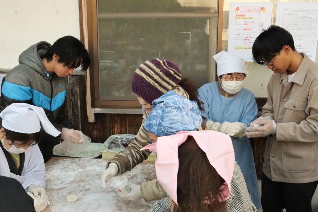 住民に教わりながらあん餅を作る留学生