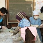 住民に教わりながらあん餅を作る留学生