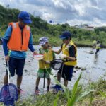 川の中に生息する生き物を探す参加者たち=岡山県津山市で