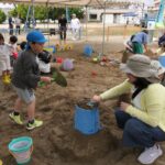 砂と水を使って思い思いに遊ぶ子どもら=岡山県津山市で