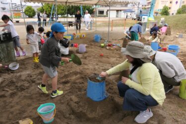 砂と水を使って思い思いに遊ぶ子どもら=岡山県津山市で
