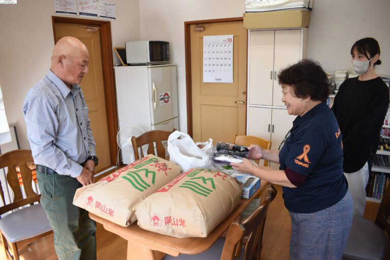 子どもたちのために新米などを贈る河本さん（左）=岡山県津山市で