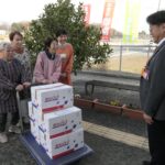 荒田局長に寄贈の黒豆煮を渡すメンバー=岡山県勝央町で