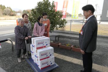 荒田局長に寄贈の黒豆煮を渡すメンバー=岡山県勝央町で