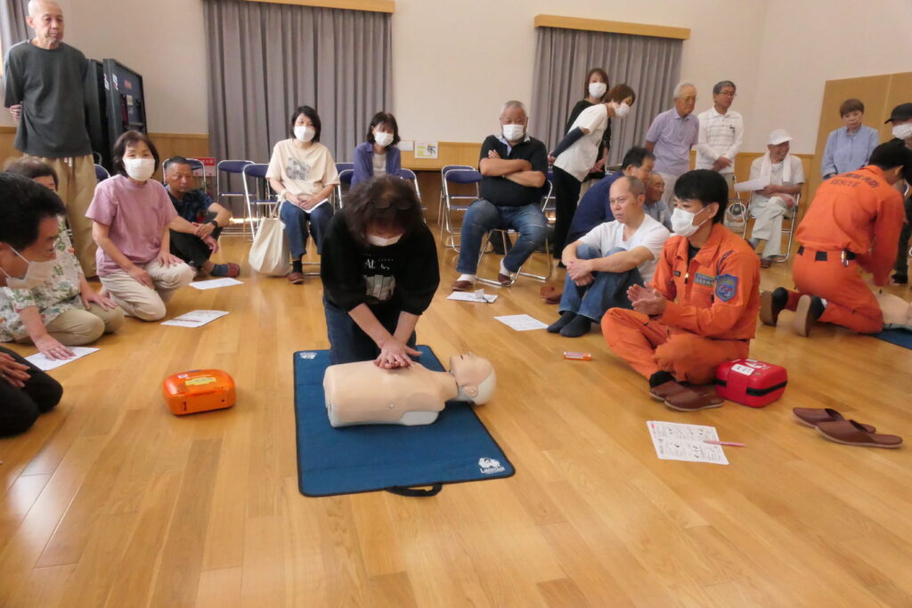 隊員のアドバイスを受けながら胸骨圧迫に取り組む参加者