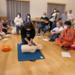 隊員のアドバイスを受けながら胸骨圧迫に取り組む参加者