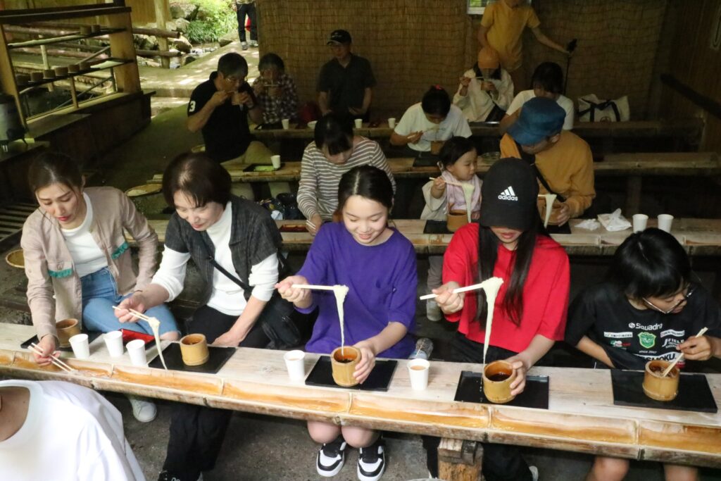 もみじ亭で流しそうめんを味わう人たち