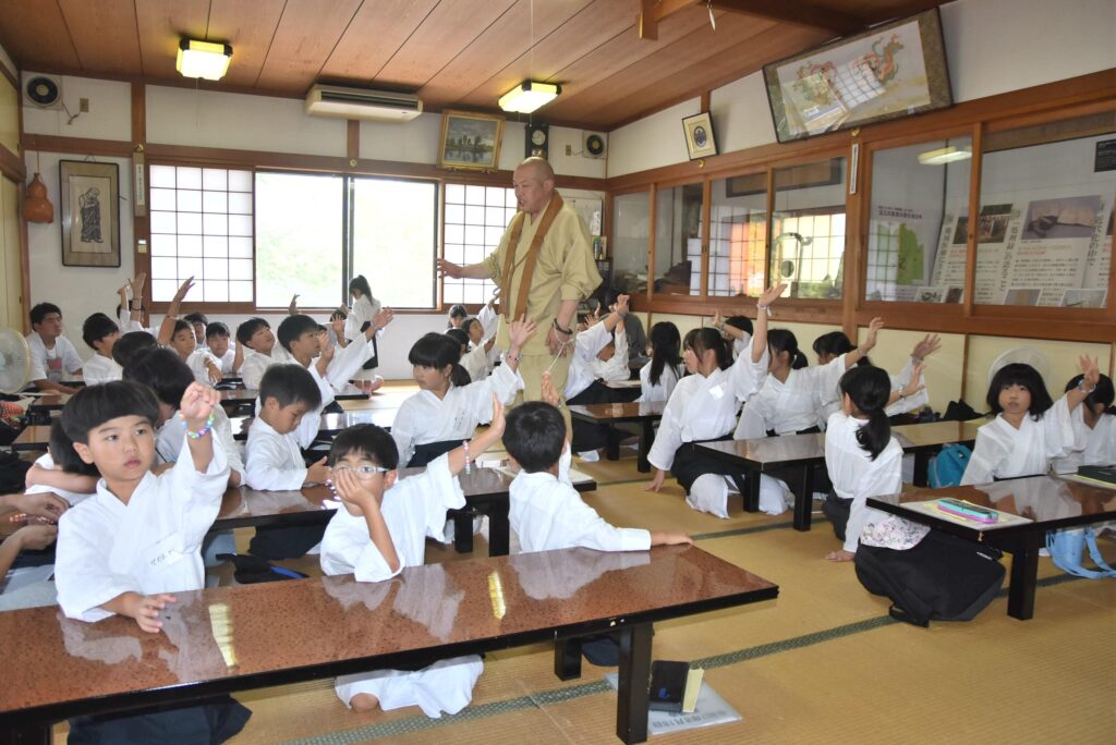仕上げた念珠を見せ合う子どもたち