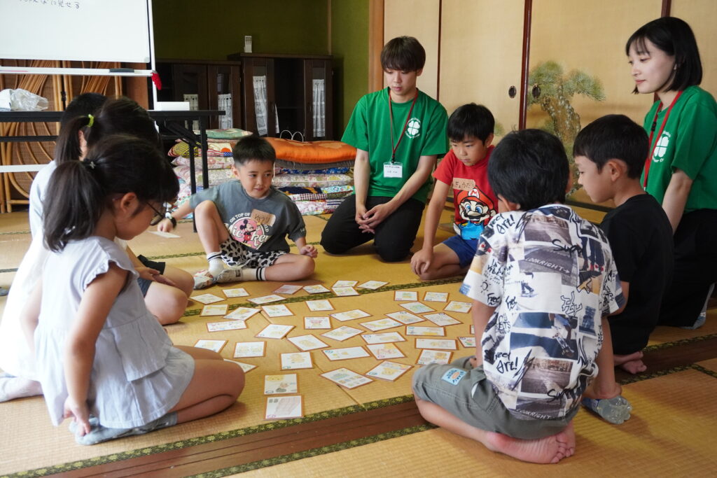 学生と一緒に「防災かるた」で遊ぶ小学生