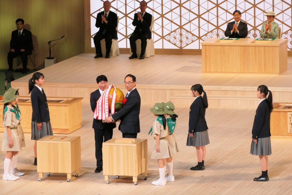 大会シンボルの木製地球儀が、次年度開催地となる埼玉県知事へ