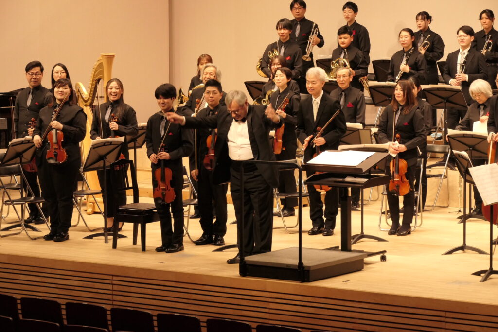 拍手を送る来場者に一礼をする出演者たち