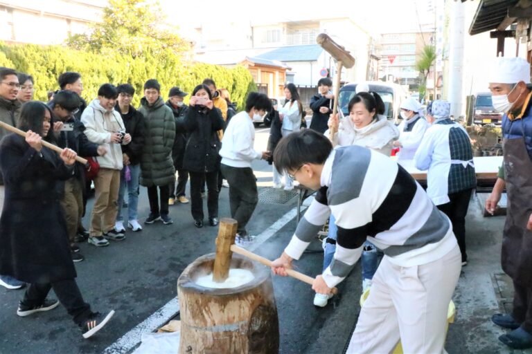 和気あいあいときねを振るう留学生たち=岡山県津山市で