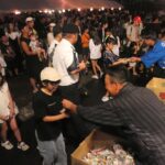 お菓子を配る倉本司令ら