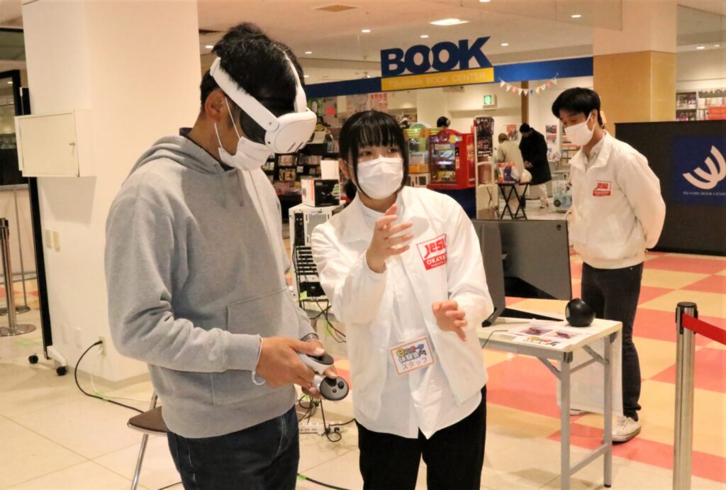 VRゴーグルを装着し、ゲームの説明を受ける来場者