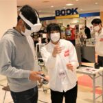 VRゴーグルを装着し、ゲームの説明を受ける来場者