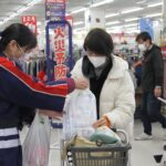 買い物客に啓発品を手渡す女性防火クラブ会員