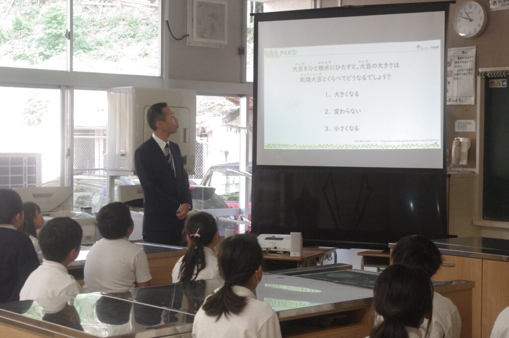 スクリーンを見て熱心に学ぶ児童たち