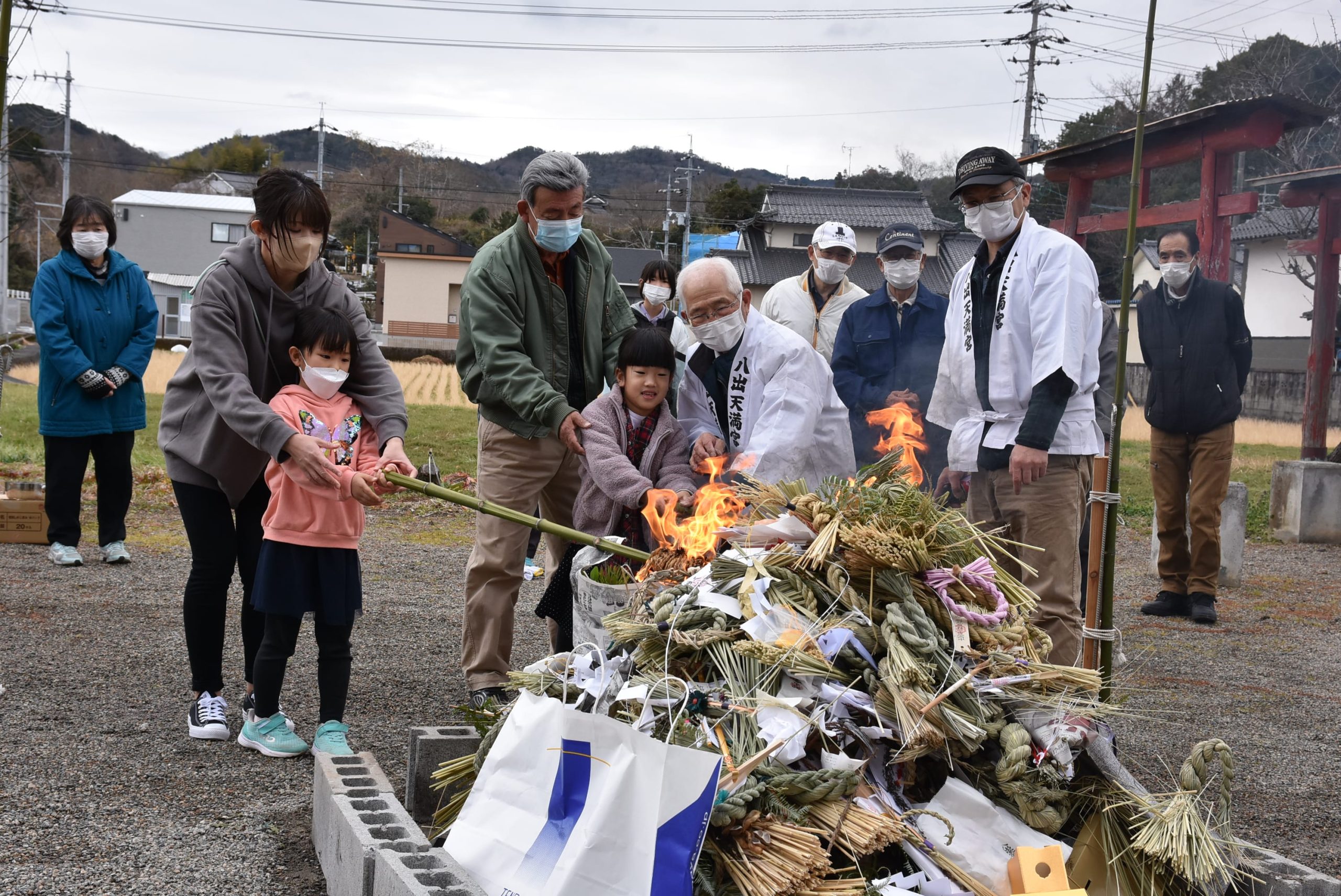 積み上げられた正月飾りに火を付ける子どもたち