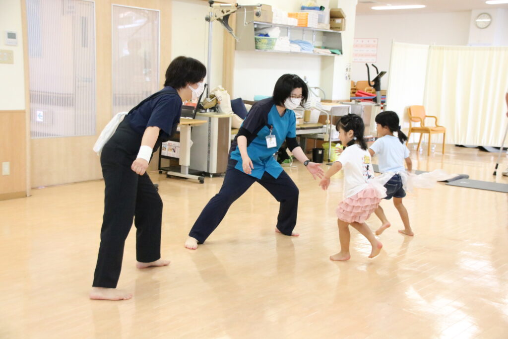 理学療法士と楽しく運動する子どもたち（日本原病院提供）