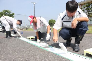 駐車場の白線引きに汗を流す高校生＝岡山県津山市、勝北中学校で
