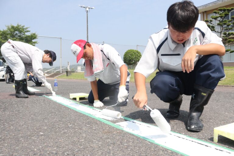 駐車場の白線引きに汗を流す高校生＝岡山県津山市、勝北中学校で