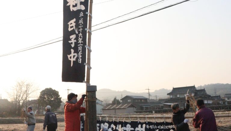 のぼり旗を立てて参拝者を迎える準備を進める氏子たち=岡山県津山市で