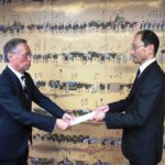 谷口市長に報告書を手渡す西山会長（右）=岡山県津山市で