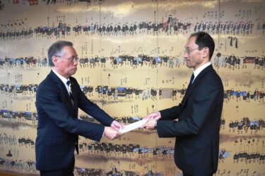 谷口市長に報告書を手渡す西山会長（右）=岡山県津山市で