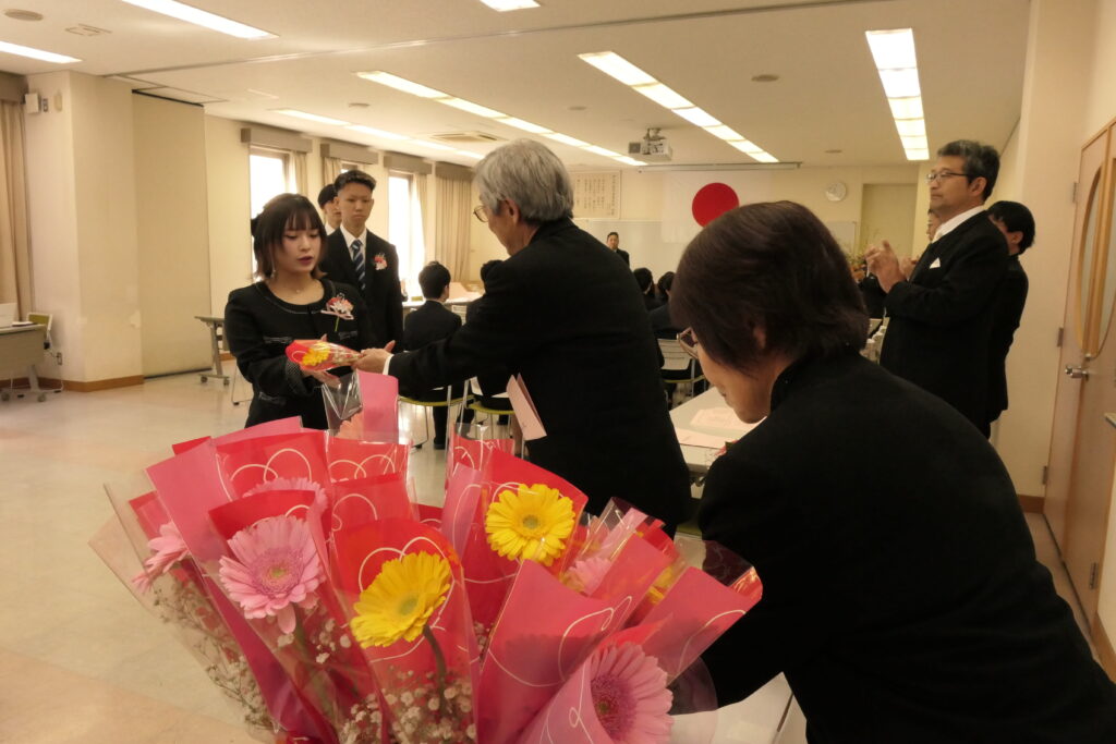 地域の人たちからの花束を受け取る卒業生たち