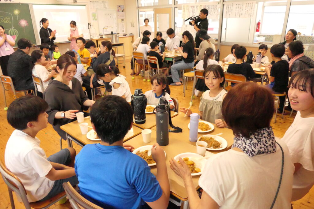 保護者や地域住民らと食事を楽しむ児童