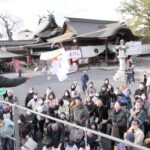 まかれた福豆に手を伸ばす参拝者=岡山県津山市で