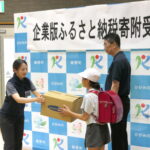 クマ鈴を手渡す城門店長＝岡山県鏡野町で