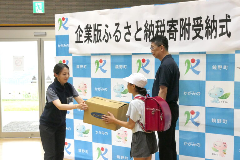 クマ鈴を手渡す城門店長＝岡山県鏡野町で