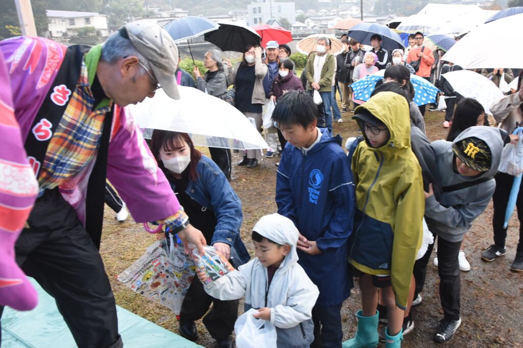 雨に負けず笑顔が広がった餅まき・菓子まき