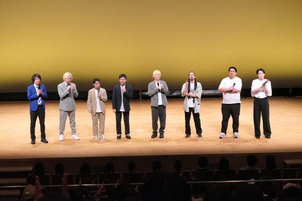 舞台であいさつをする出演者たち