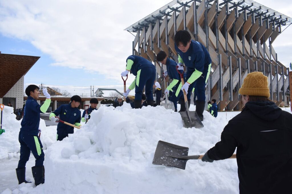 雪の感触を楽しみながら作業に励む生徒たち