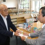 児童図書を贈る田淵会長（左）
