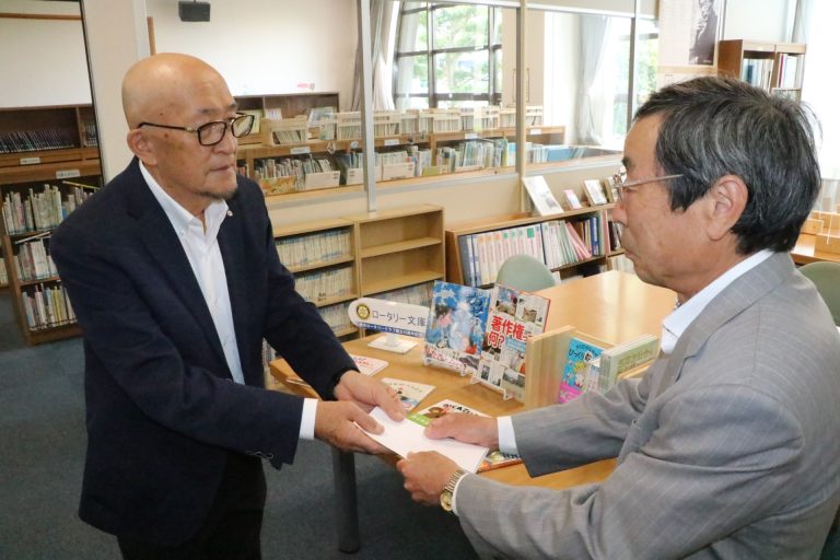 児童図書を贈る田淵会長（左）