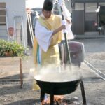 青竹の矛で湯をかき混ぜる吉田宮司