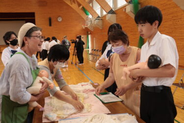 人形を使って赤ちゃんの抱き方を学ぶ生徒たち=岡山県真庭市で