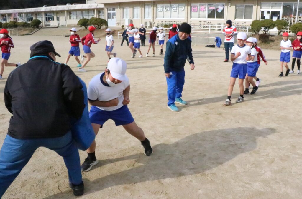 タックルを体験する児童たち=岡山県美作市楢原中の美作北小学校で