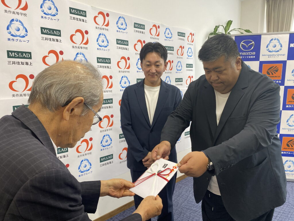美作学園の藤原理事長(左)に目録を手渡す美作グループの川嶋社長(右)ら