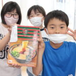 一蘭から寄贈されたラーメンを手にする子どもたち