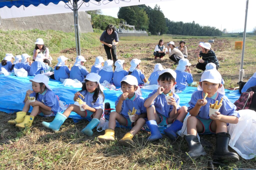 サツマイモを揚げたおやつを仲良く食べる園児たち=岡山県鏡野町で