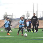 湯郷ベルの選手に教わりながら、真剣な表情で取り組む子どもたち=岡山県津山市で