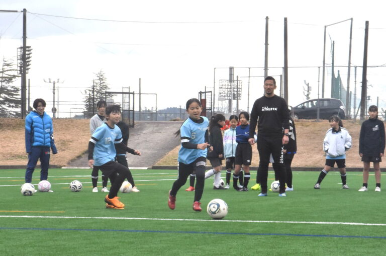 湯郷ベルの選手に教わりながら、真剣な表情で取り組む子どもたち=岡山県津山市で