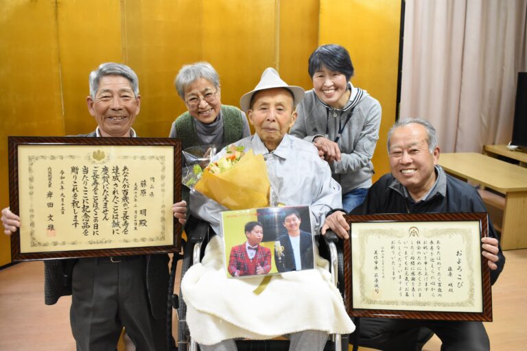 家族に囲まれ、100歳の祝福を受ける藤原さん（中央）=岡山県津山市で