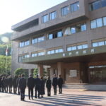 国旗・市旗の降納を見守る職員ら＝岡山県美作市、現美作市役所本庁舎で