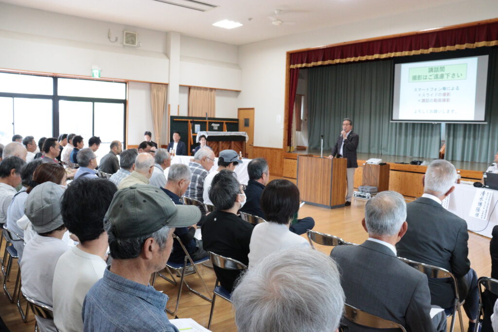 あいさつする髙山康晴会長