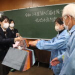 民生委員にプレゼンを預ける生徒たち